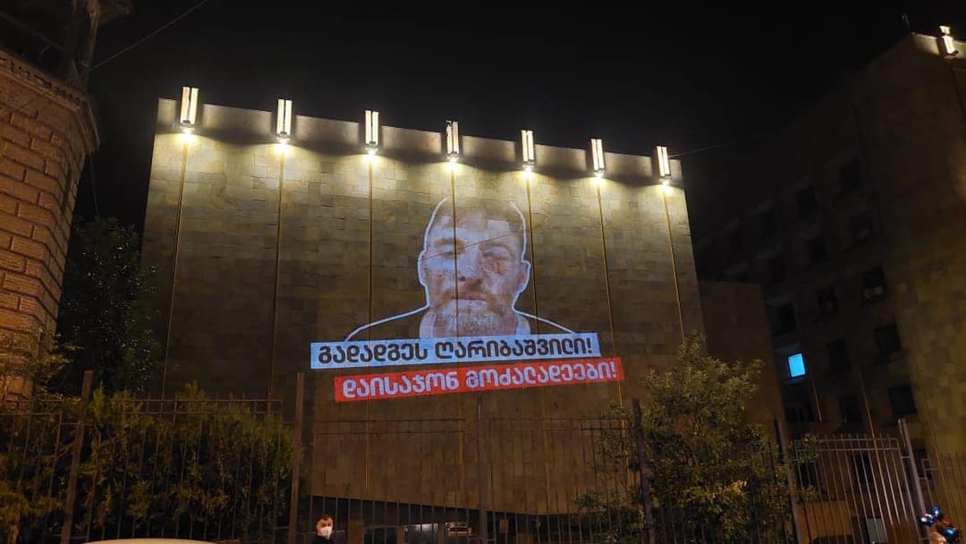 მთავრობის ადმინისტრაციის შენობაზე ლექსო ლაშქარავას ფოტო და მოთხოვნები გაანათეს