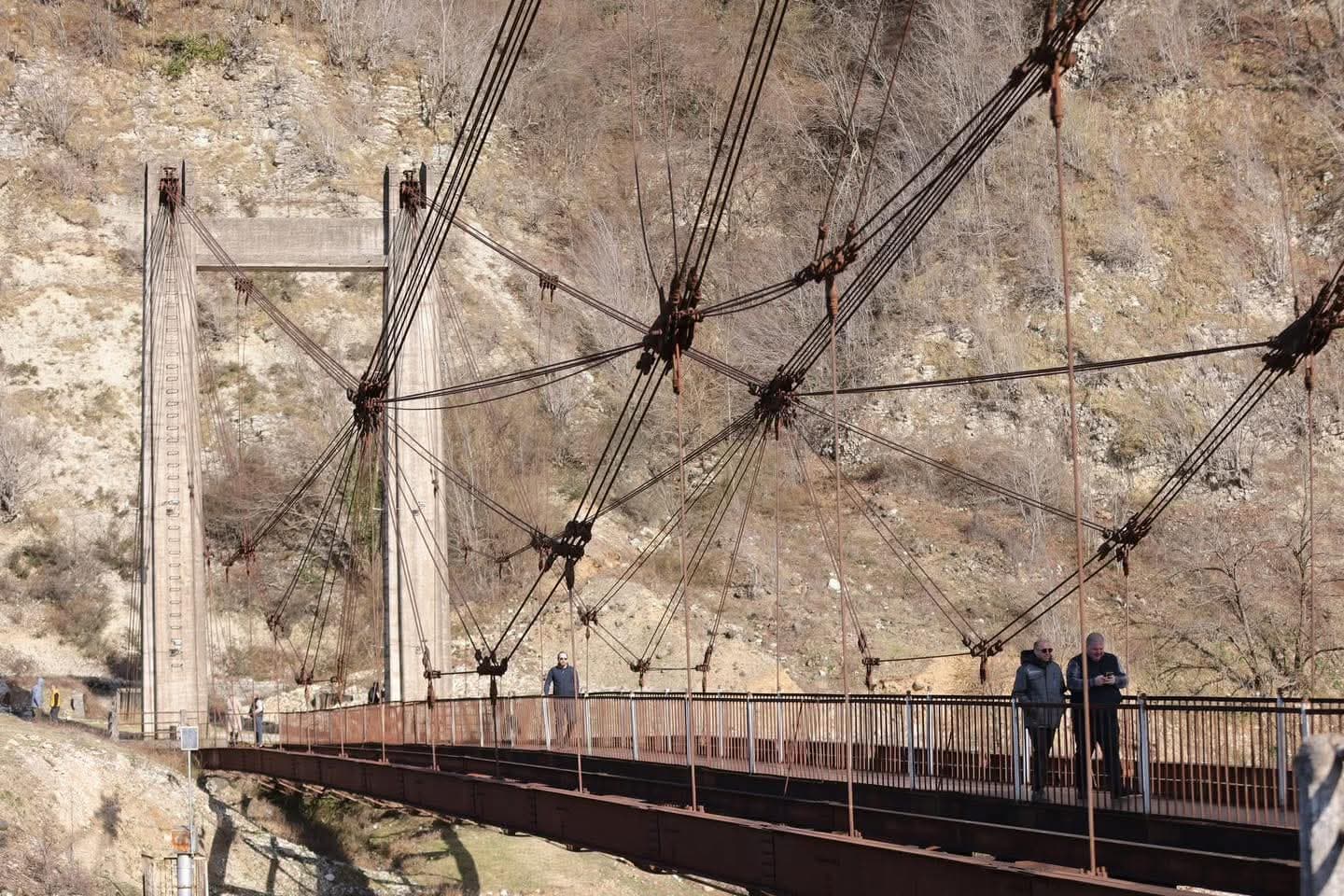 <p style="text-align: justify">Work has begun on a project to rehabilitate the historic suspension bridge over the Magana River in the town of Jvari, in Georgia’s northwestern Tsalenjikha Municipality, and develop it into a tourist attraction.</p><p style="text-align: justify">The initiative is being led by the Ministry of Infrastructure of Georgia, which plans to restore the structure and integrate it into the region’s tourism offering.</p><p style="text-align: justify">The 80-metre pedestrian bridge, built in 1931–1932, is currently damaged. It has been granted the status of a cultural heritage monument.</p><p style="text-align: justify">Infrastructure Minister Revaz Sokhadze inspected the site together with Municipal Development Fund Executive Director Beka Urushadze, Roads Department Chair Levan Darakhvelidze, Member of Parliament Ilia Injia, representatives of the local government, and Enguri Attraction Director Nikoloz Antidze.</p><p style="text-align: justify">Officials reviewed the current condition of the bridge and discussed plans for its rehabilitation and future tourism use.</p>